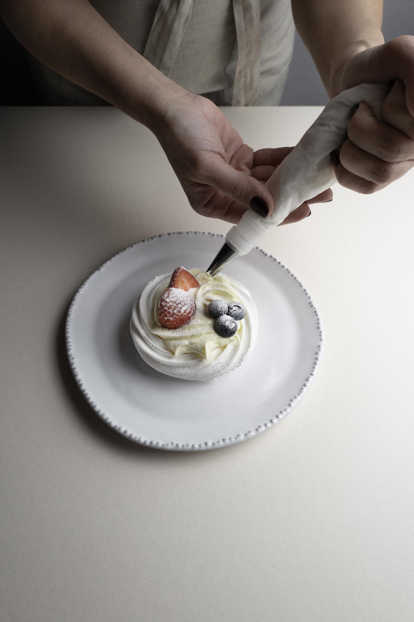 Dettaglio mani che decorano un piatto